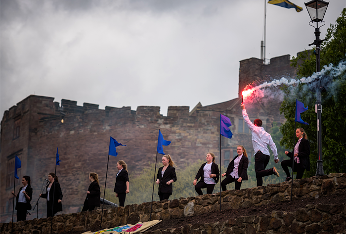 dancers with flare in front of castle